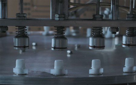 Équipement entièrement automatique de capsulage  pour couvercles avec bec verseur